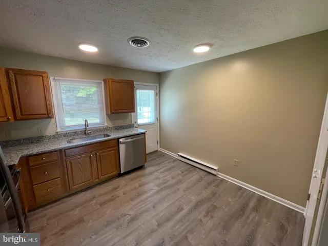 a kitchen with granite countertop a sink and a stove top oven