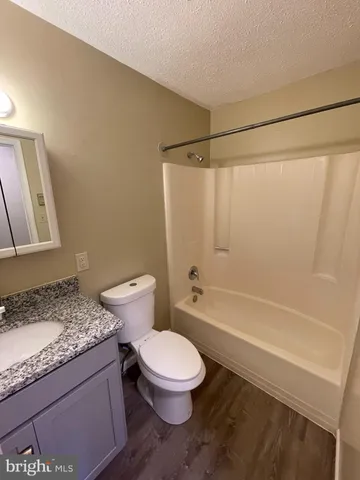 a bathroom with a granite countertop toilet a sink and a bathtub