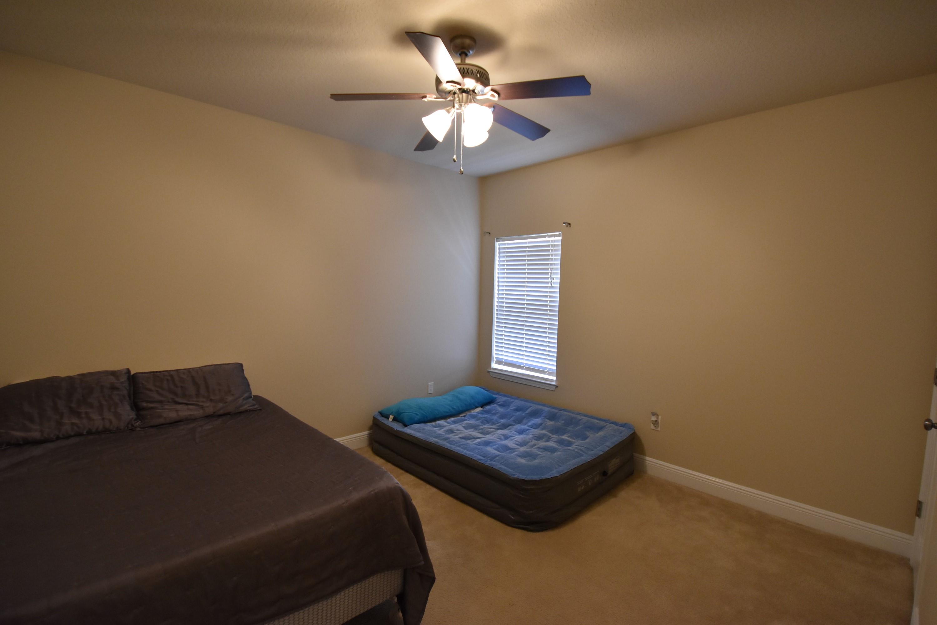 640 Red Fern Road Crestview, FL 32536 - Photo 28 of 50 a bedroom with a bed and a chandelier