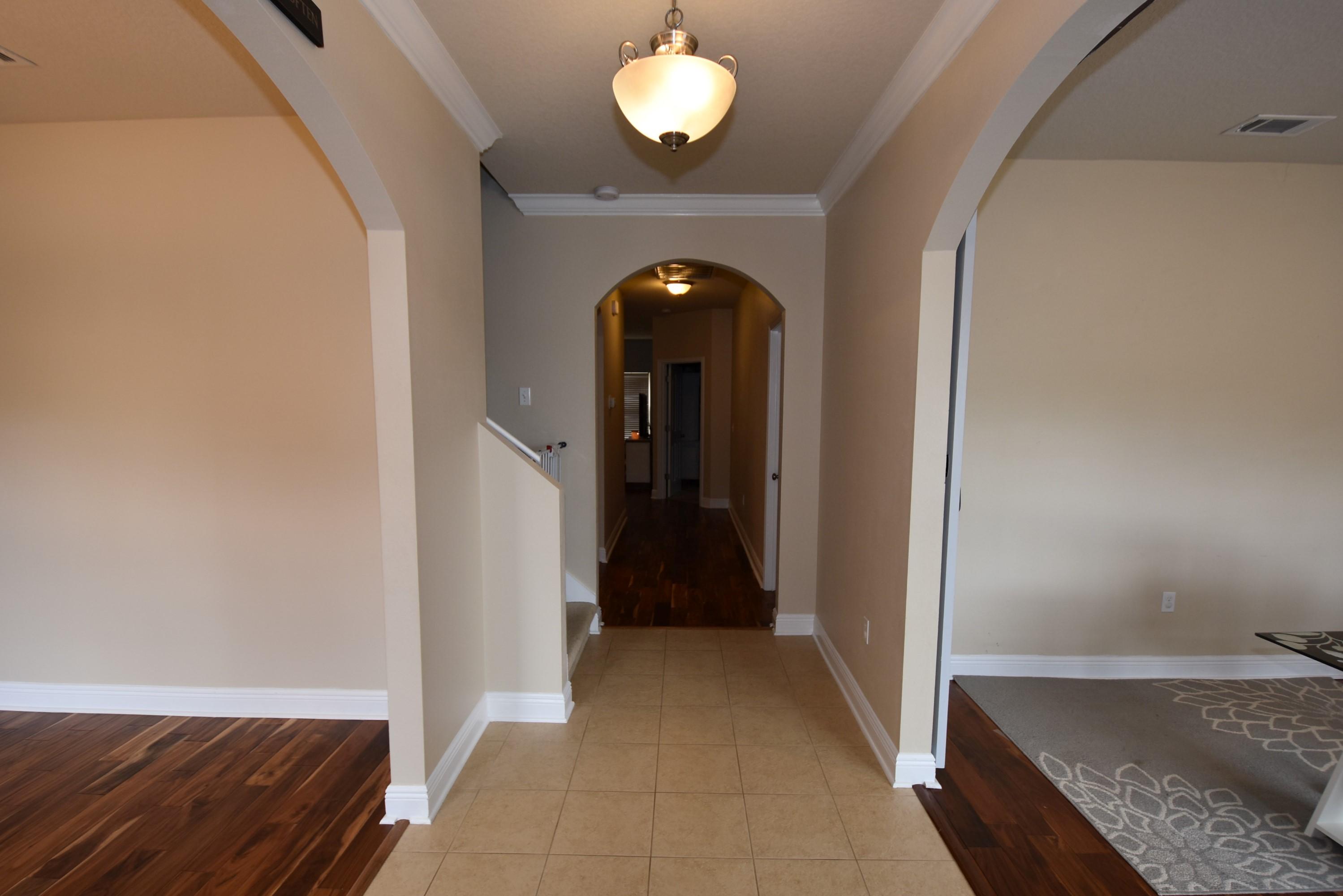 640 Red Fern Road Crestview, FL 32536 - Photo 42 of 50 a view of a hallway with wooden floor and a chandelier