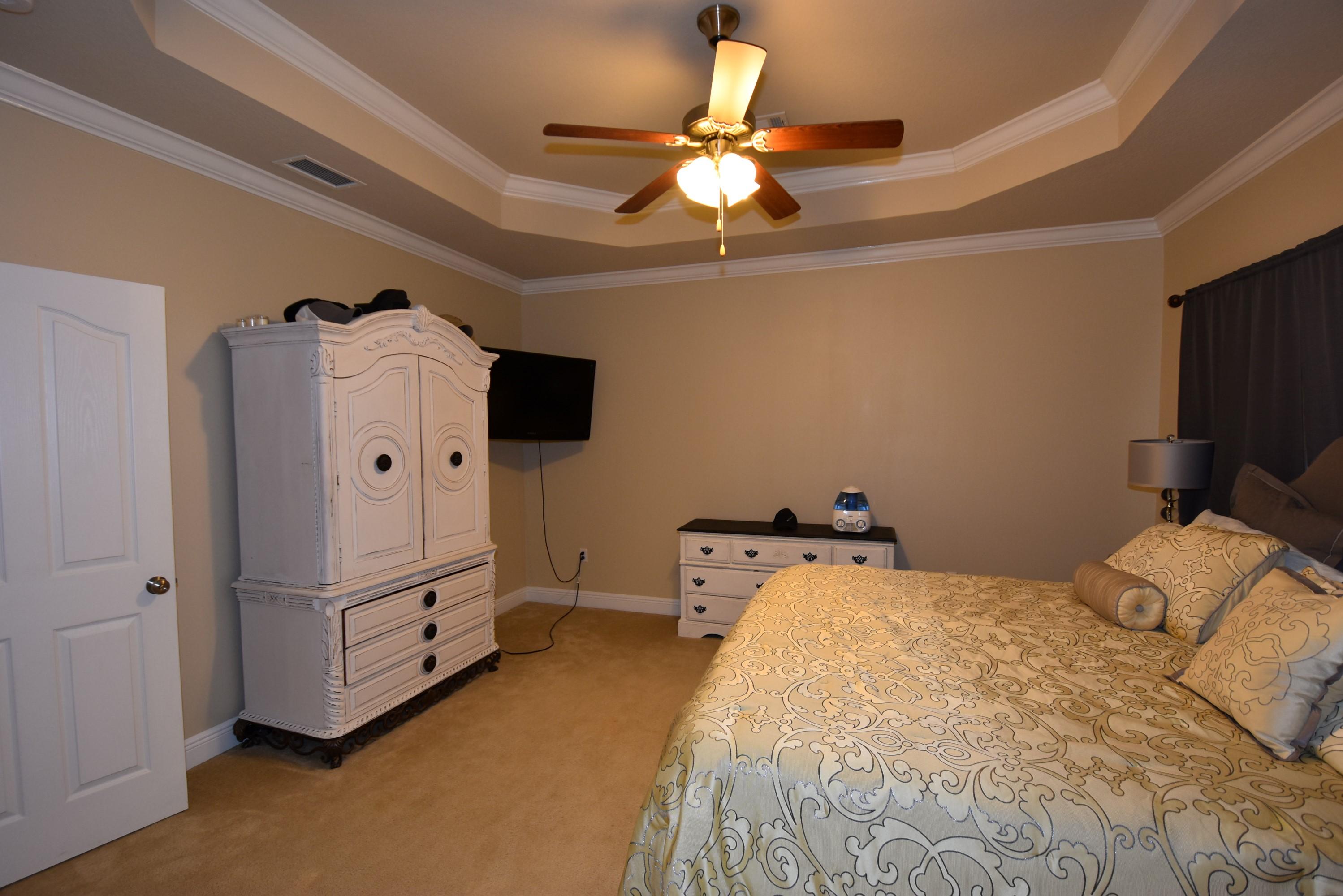 640 Red Fern Road Crestview, FL 32536 - Photo 46 of 50 a bedroom with bed and a chandelier
