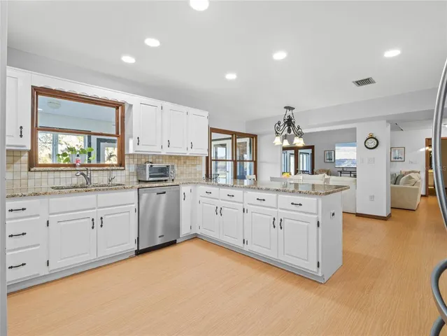 a kitchen with stainless steel appliances granite countertop a sink stove and cabinets