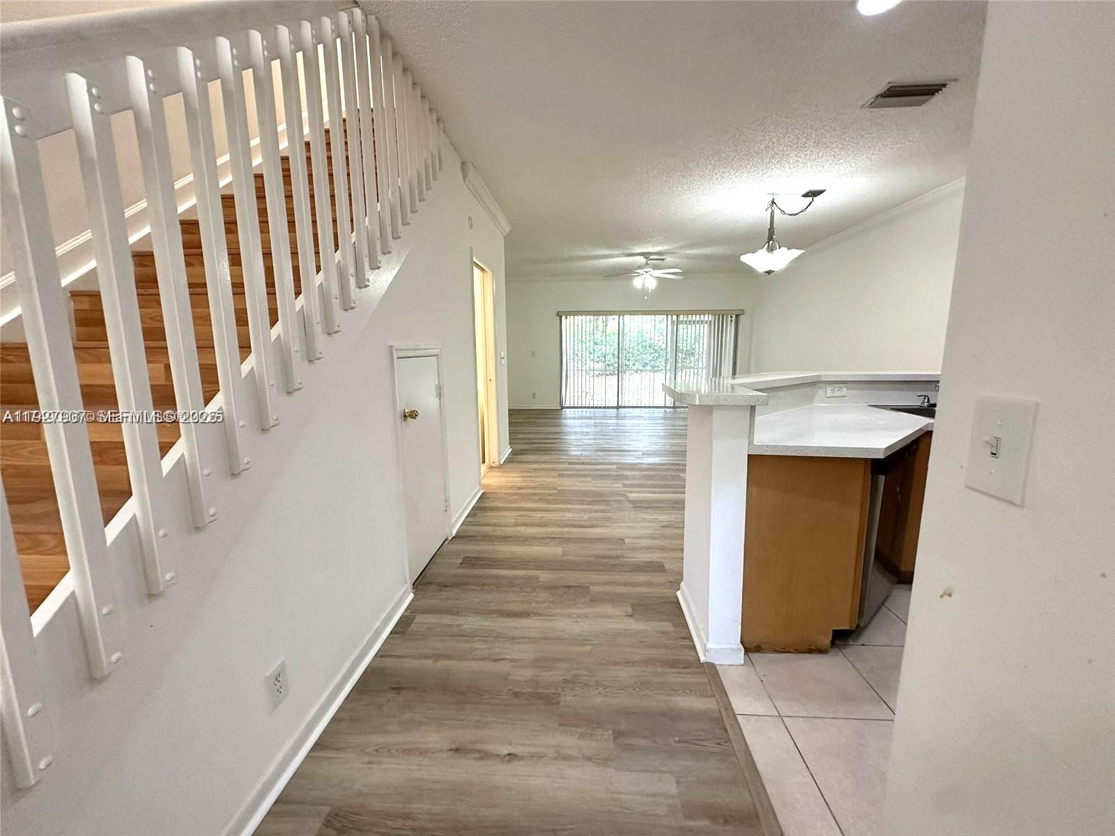 4855 Palmbrooke Circle, Unit 4855 West Palm Beach, FL 33417 - Photo 16 of 40 a view of a hallway with wooden floor and staircase