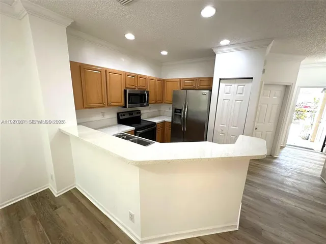 a kitchen with stainless steel appliances a refrigerator sink and microwave
