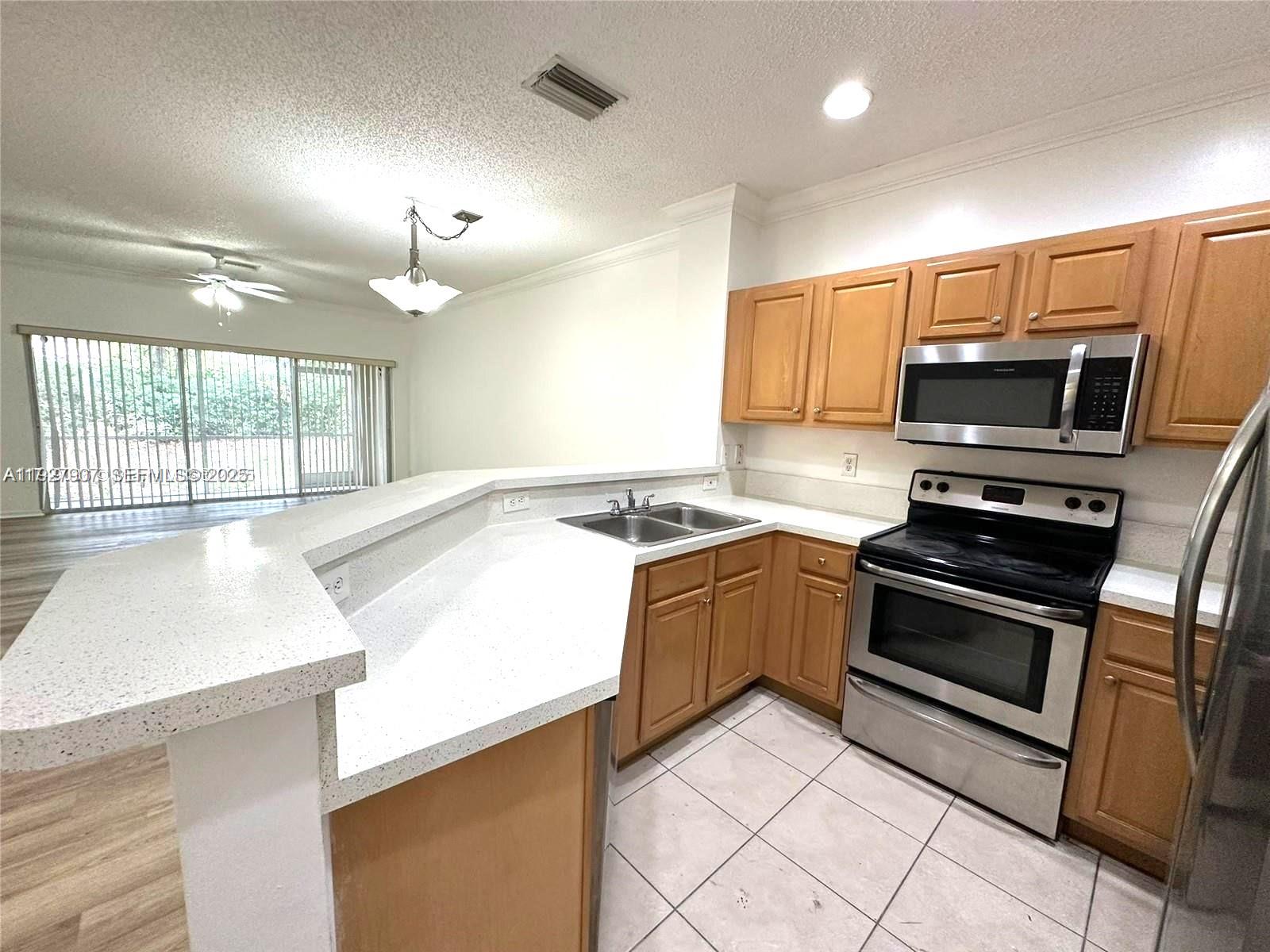 4855 Palmbrooke Circle, Unit 4855 West Palm Beach, FL 33417 - Photo 19 of 40 a kitchen with a sink stove and microwave