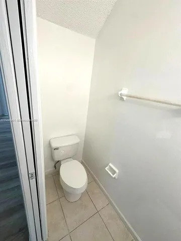 a white toilet sitting next to a shower