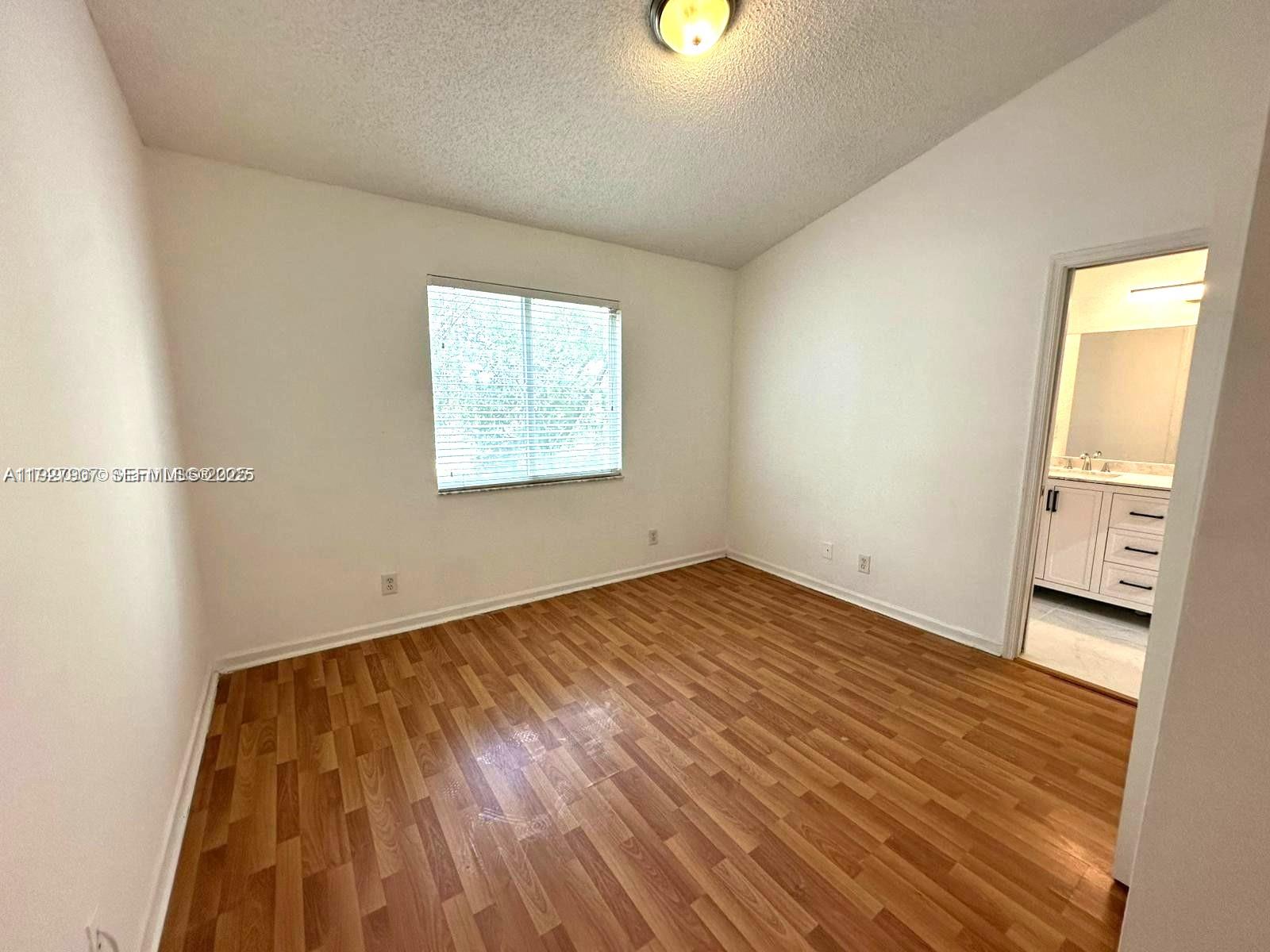 4855 Palmbrooke Circle, Unit 4855 West Palm Beach, FL 33417 - Photo 27 of 40 an empty room with wooden floor and windows