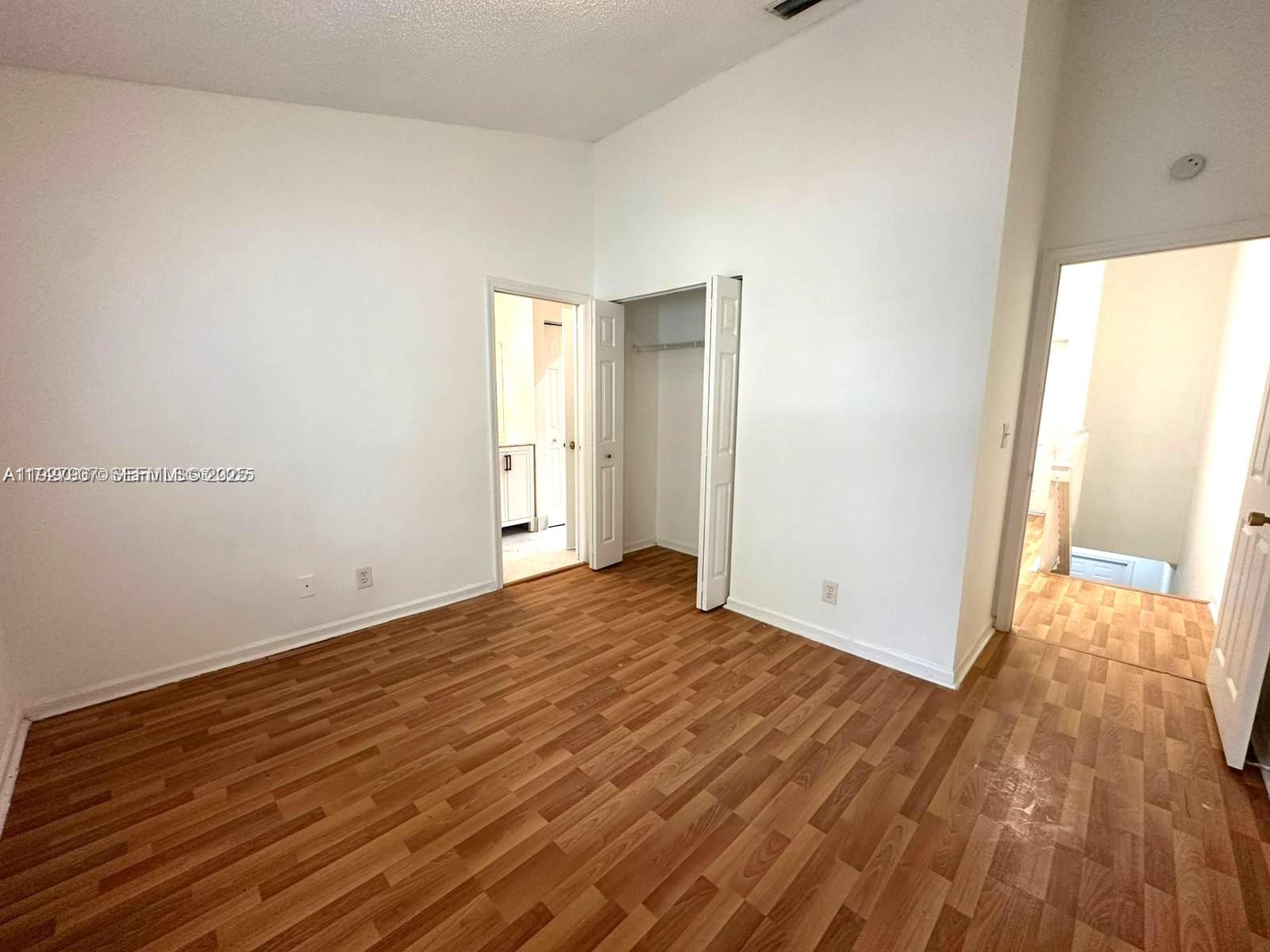 4855 Palmbrooke Circle, Unit 4855 West Palm Beach, FL 33417 - Photo 28 of 40 a view of an empty room and wooden floor