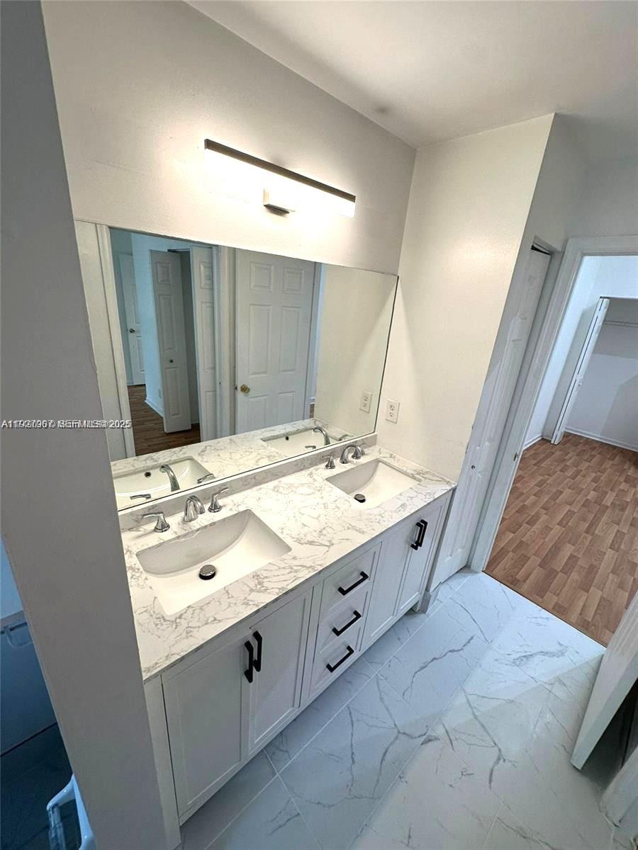 4855 Palmbrooke Circle, Unit 4855 West Palm Beach, FL 33417 - Photo 32 of 40 a bathroom with a granite countertop sink and a mirror