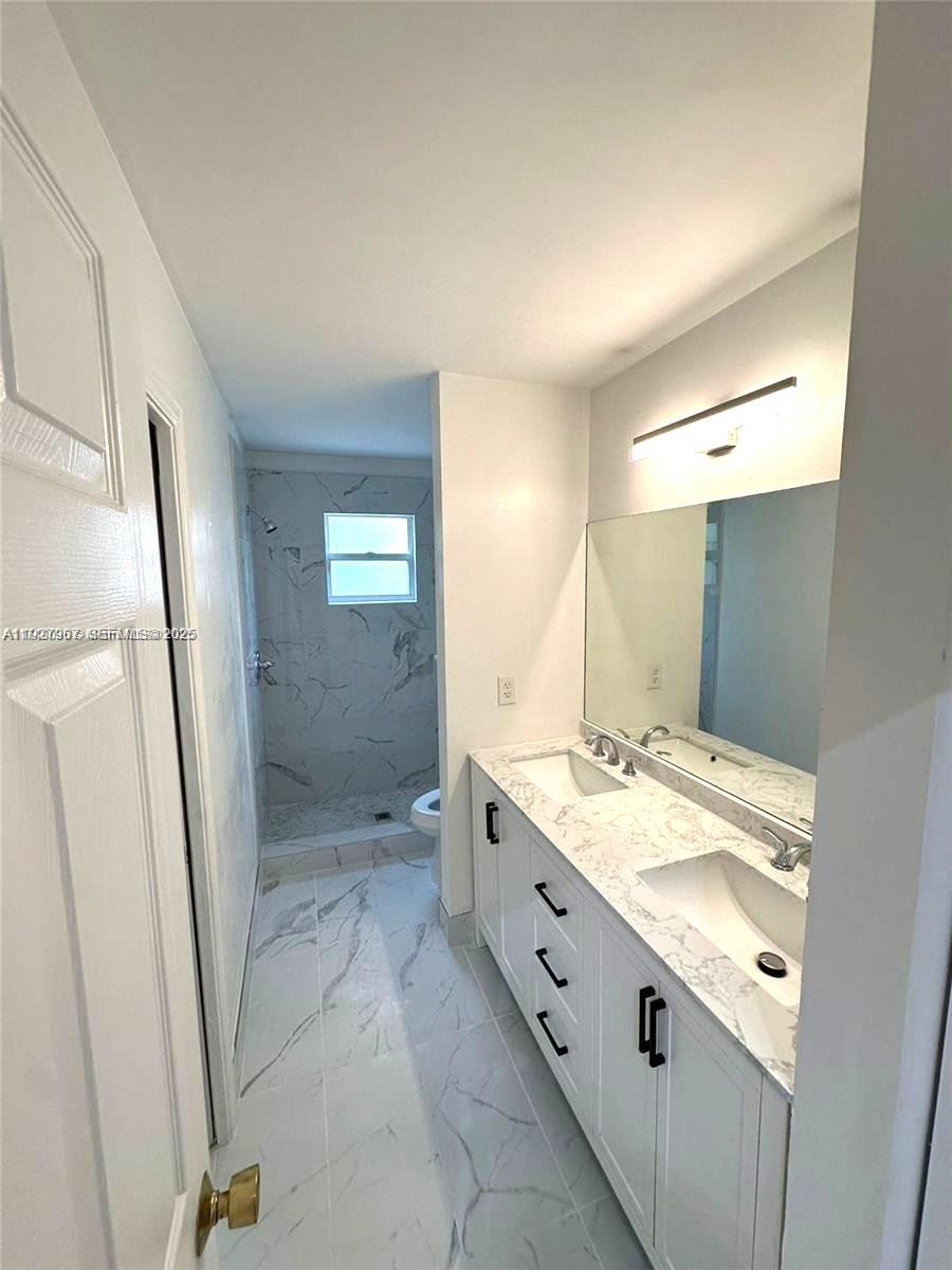 4855 Palmbrooke Circle, Unit 4855 West Palm Beach, FL 33417 - Photo 33 of 40 a bathroom with a granite countertop sink mirror and shower