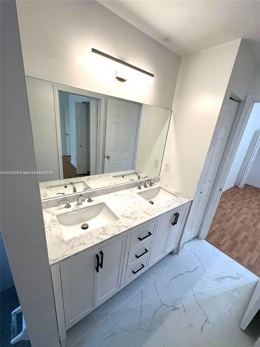 4855 Palmbrooke Circle, Unit 4855 West Palm Beach, FL 33417 - Photo 34 of 40 a bathroom with a sink vanity and mirror