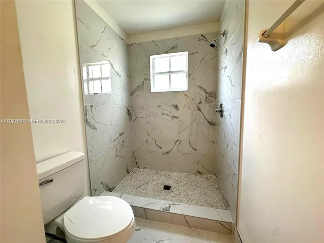 a bathroom with a shower toilet and sink