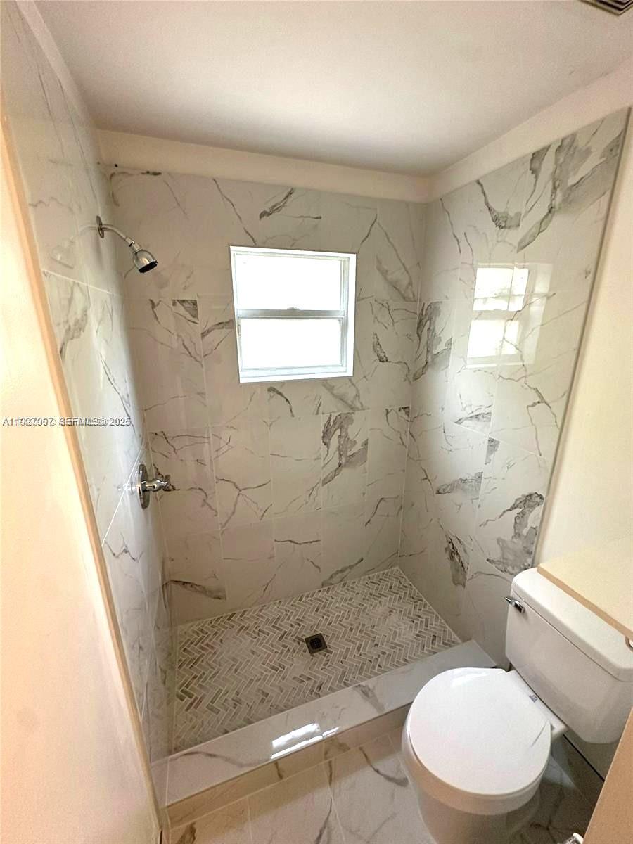 4855 Palmbrooke Circle, Unit 4855 West Palm Beach, FL 33417 - Photo 38 of 40 a bathroom with a toilet a sink and shower