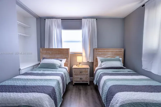 a bedroom with two beds and a large window