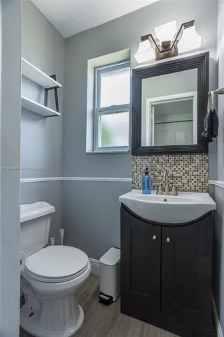 a bathroom with a toilet sink and mirror