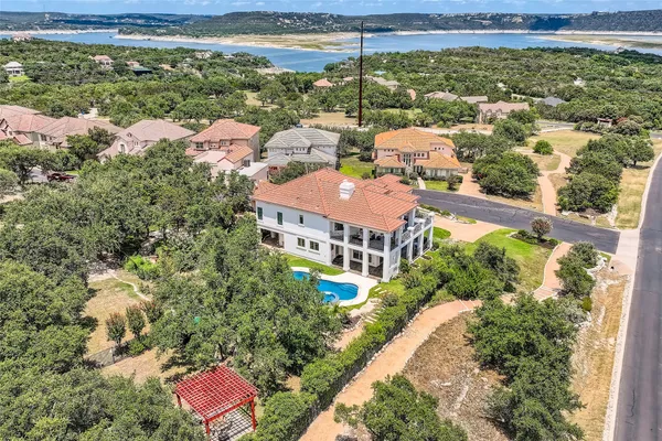 a view of a house with a yard fire pit and a large tree