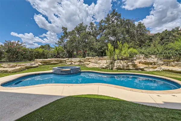 a view of swimming pool with outdoor seating and yard in back