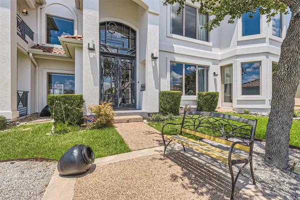 a view of a brick house with a yard and plants