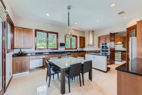 a kitchen with stainless steel appliances granite countertop a sink a stove and a refrigerator