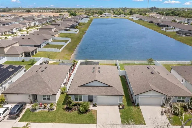 an aerial view of residential houses with outdoor space and parking