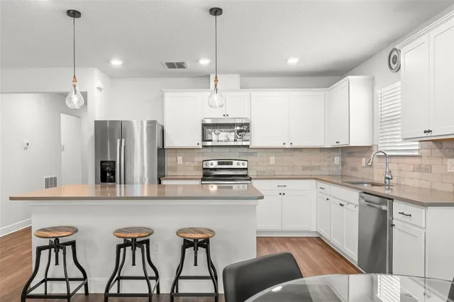 a kitchen with stainless steel appliances granite countertop a stove a sink island and a refrigerator