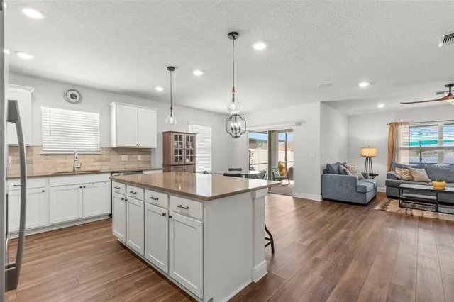 a kitchen with stainless steel appliances granite countertop wooden floors a sink and cabinets