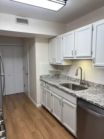a kitchen with granite countertop a sink and cabinets