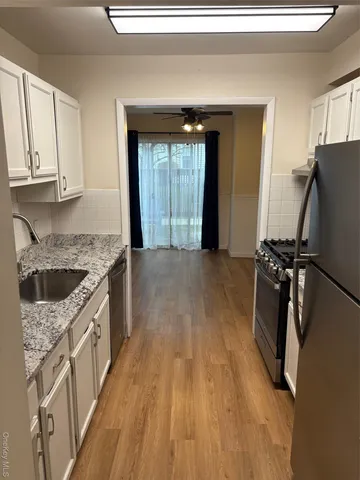 a kitchen with granite countertop a sink stove and refrigerator