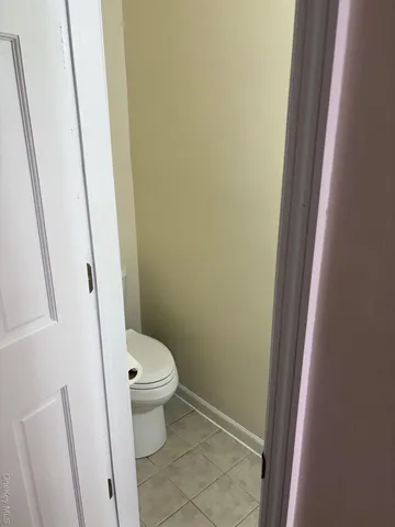 a white toilet sitting next to a wooden floor