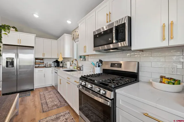 a kitchen with stainless steel appliances granite countertop a sink stove and refrigerator