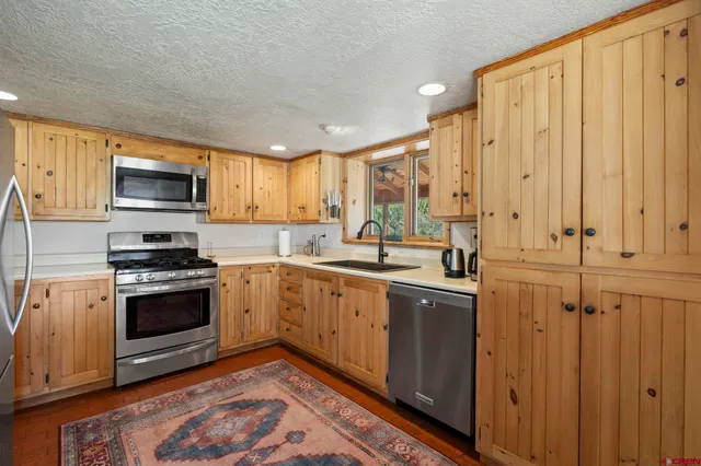 a kitchen with stainless steel appliances granite countertop a stove a sink and a microwave