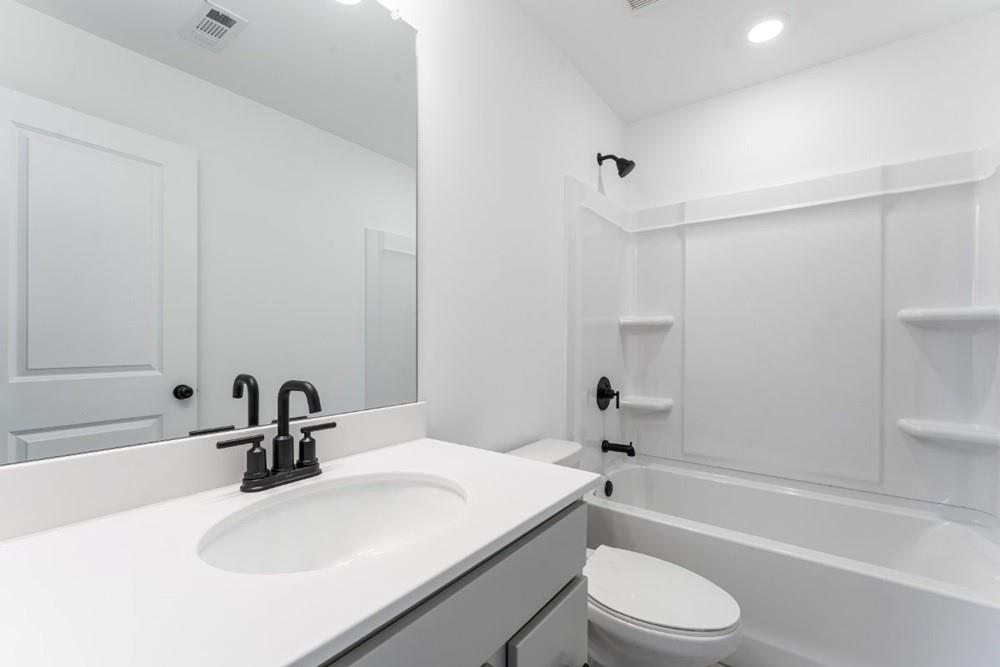 3197 Eastham Run Drive Dacula, GA 30019 - Photo 28 of 34 a bathroom with a sink a toilet and a bathtub