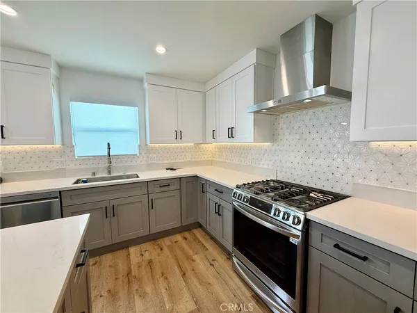 a kitchen with granite countertop a sink stove and cabinets