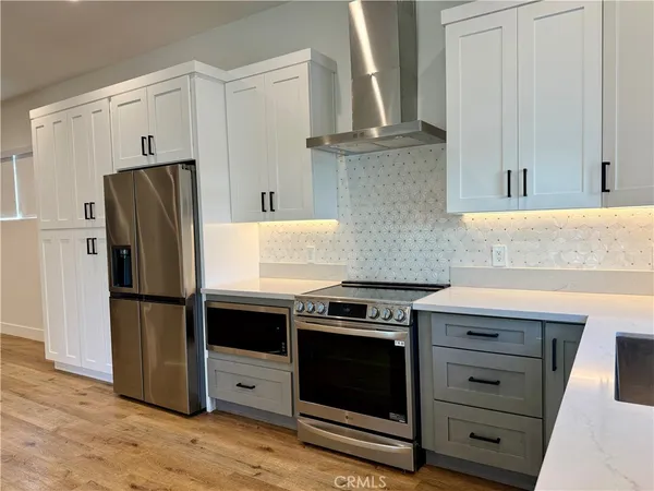 a kitchen with granite countertop white cabinets and stainless steel appliances