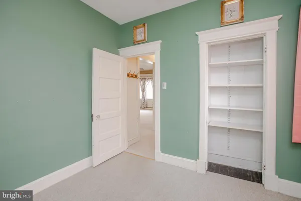 a view of an empty room with cabinet and entryway