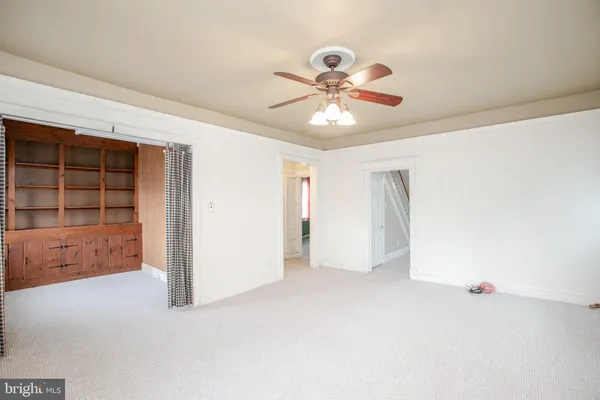 an empty room with closet and windows