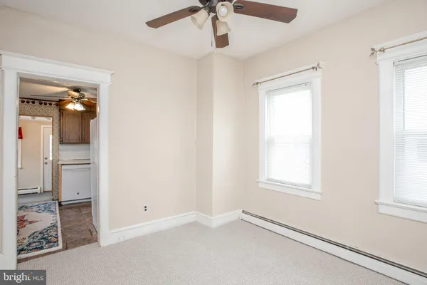 an empty room with windows and fan
