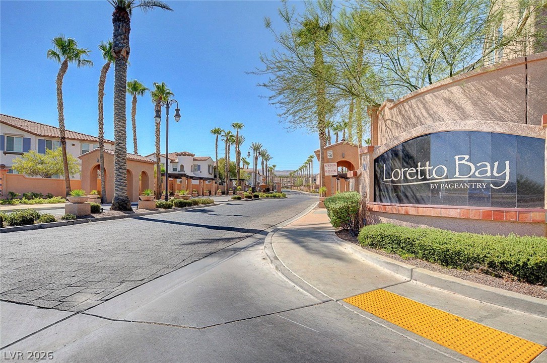 48 Jasmine Point Street Henderson, NV 89074 - Photo 9 of 62 An inviting gated community entrance with lush landscaping and towering palm trees.