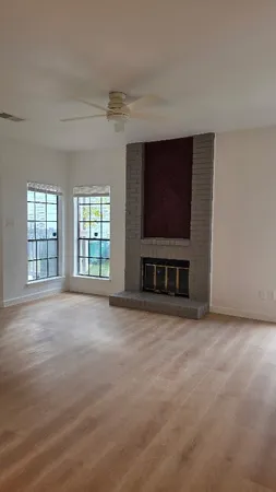 a view of an empty room with a fireplace and a window