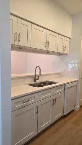 a kitchen with white cabinets and a sink