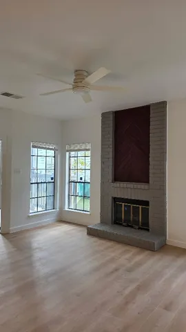 a view of an empty room with a fireplace and a window