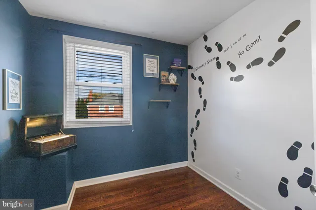 a view of a livingroom with wooden floor and a window