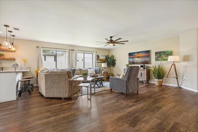 a living room with patio furniture and a wooden floor