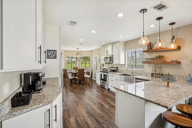 a kitchen with a refrigerator and a stove top oven