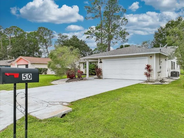 a view of a house with backyard and a tree