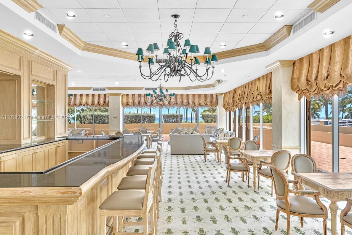 8855 Collins Avenue, Unit 2F Surfside, FL 33154 - Photo 16 of 79 a view of a dining room with furniture a chandelier and large windows