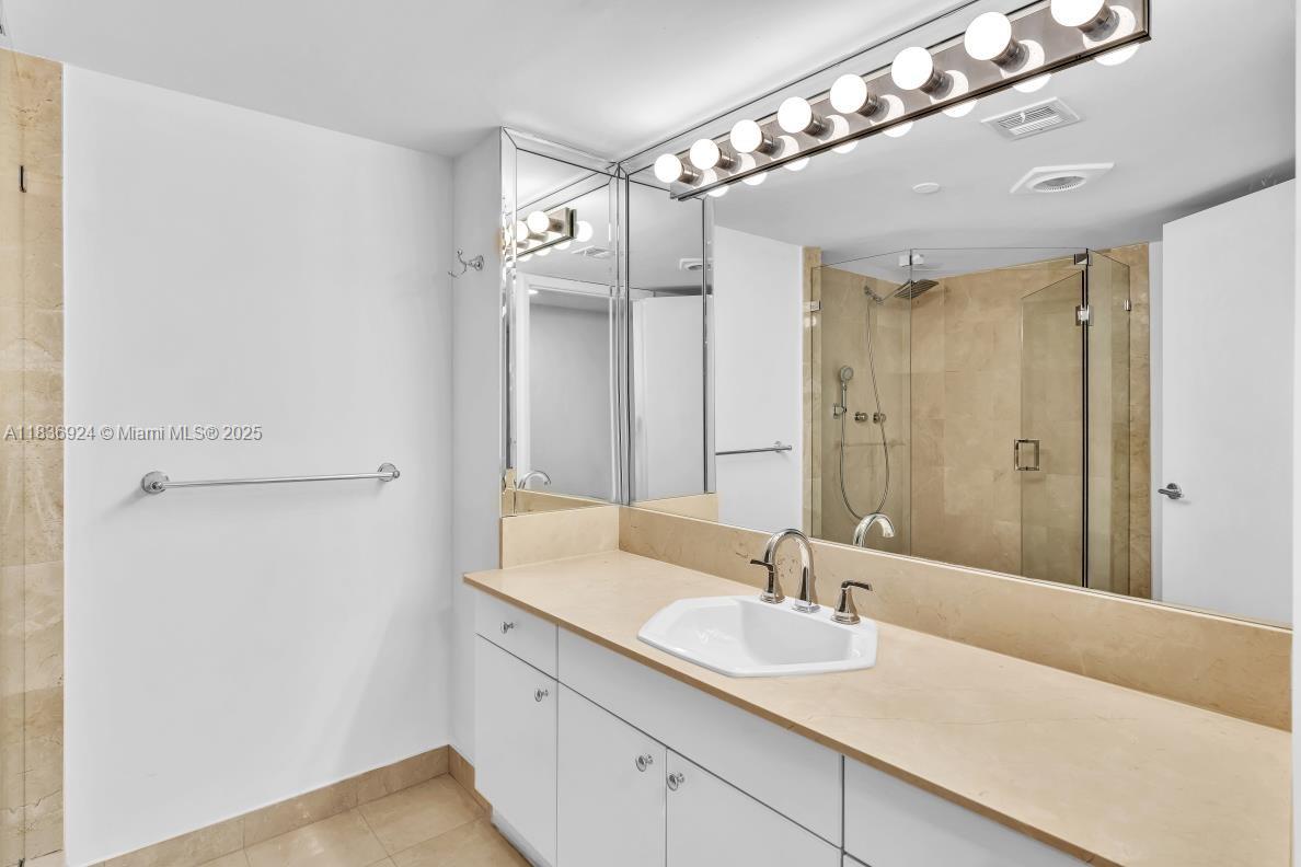 8855 Collins Avenue, Unit 2F Surfside, FL 33154 - Photo 25 of 79 a en suite bathroom with a double vanity sink and mirror