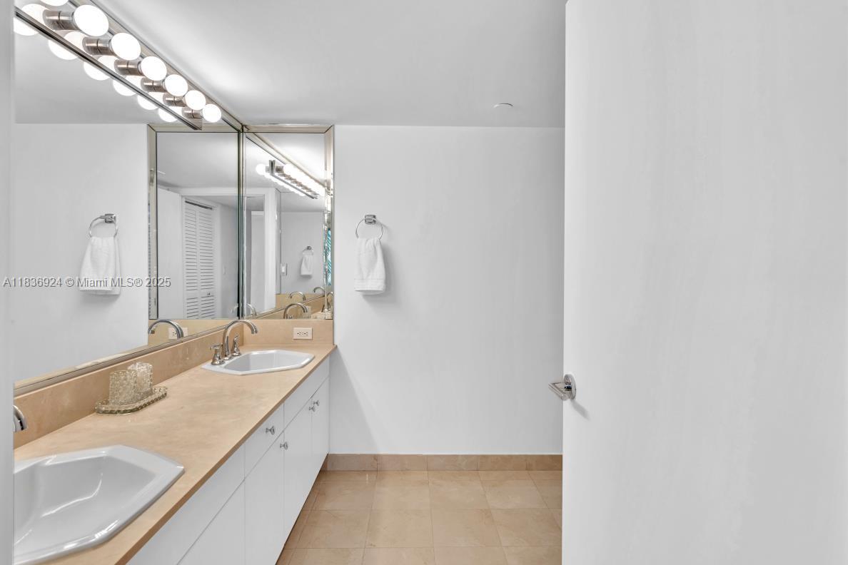 8855 Collins Avenue, Unit 2F Surfside, FL 33154 - Photo 29 of 79 a bathroom with a sink and a mirror