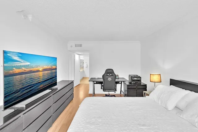 a view of a hallway with wooden floor and a bedroom