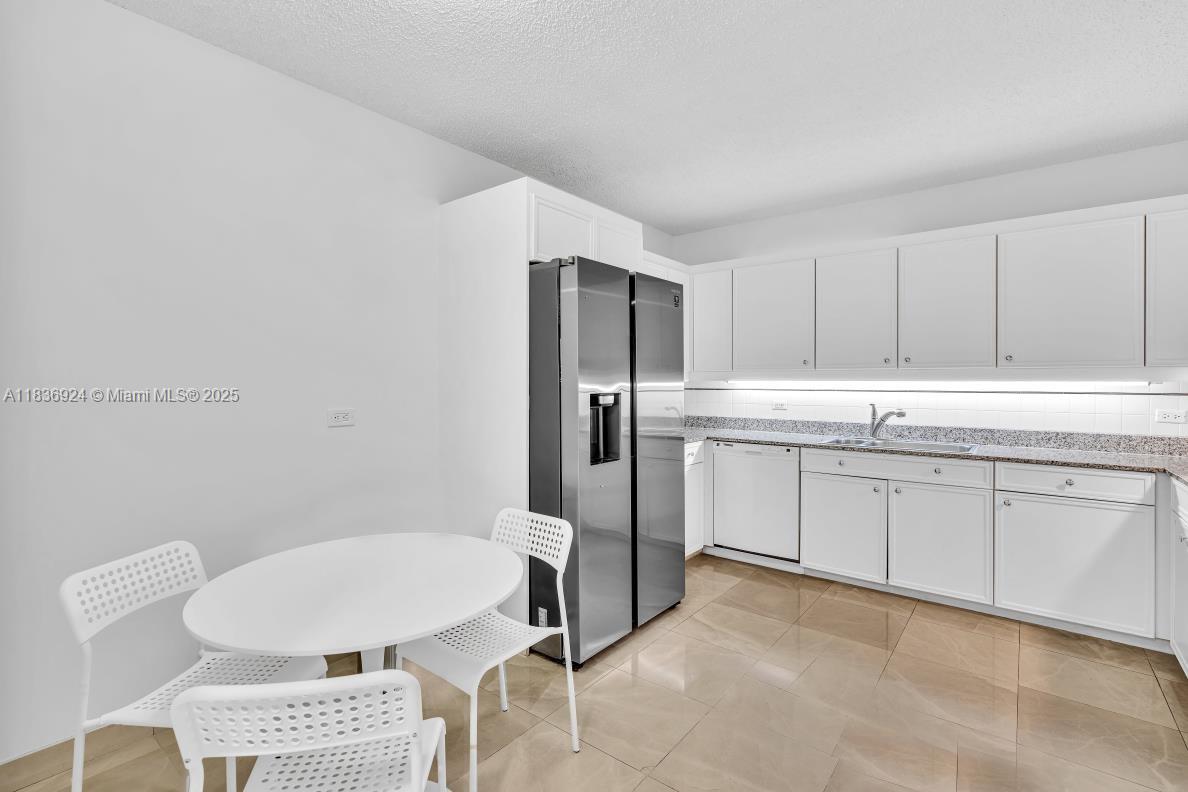 8855 Collins Avenue, Unit 2F Surfside, FL 33154 - Photo 34 of 79 a kitchen with a sink cabinets and refrigerator